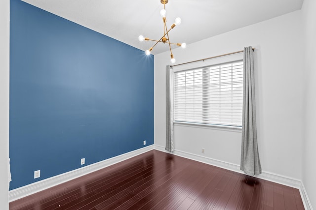 empty room featuring hardwood / wood-style floors and an inviting chandelier