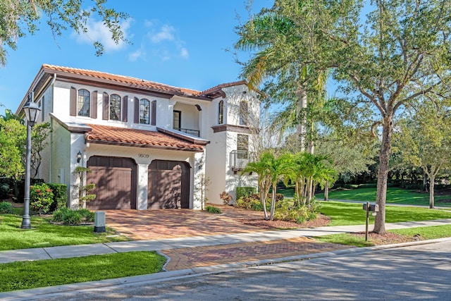 mediterranean / spanish-style home with a front lawn and a garage