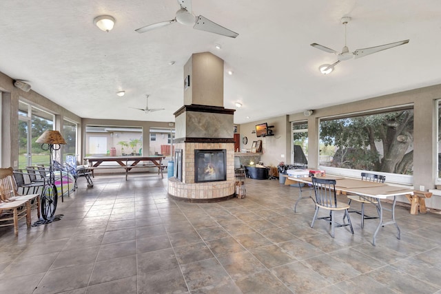 view of patio featuring ceiling fan and a fireplace