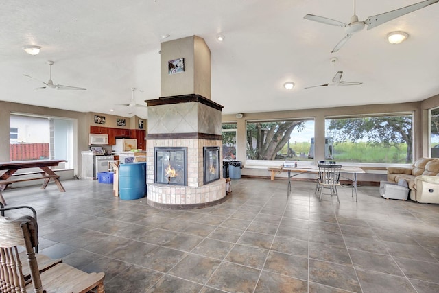 unfurnished living room with a multi sided fireplace and a high ceiling