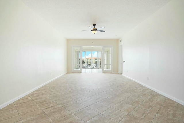 tiled spare room with ceiling fan, french doors, and a textured ceiling