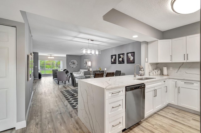 kitchen with white cabinetry, dishwasher, sink, and kitchen peninsula