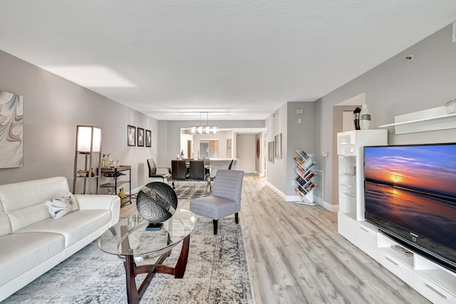 living room with light hardwood / wood-style flooring and a notable chandelier