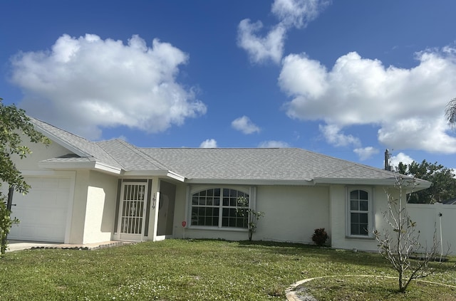 rear view of house featuring roof with shingles, a yard, stucco siding, an attached garage, and fence