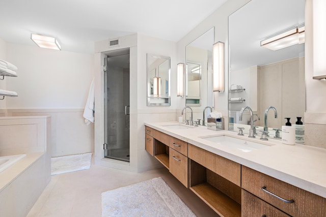 bathroom featuring tile patterned flooring, vanity, and shower with separate bathtub