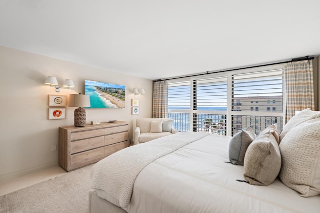 carpeted bedroom featuring access to exterior and a water view