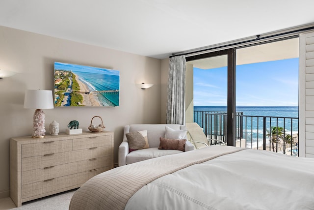 bedroom with access to exterior, light carpet, and a water view