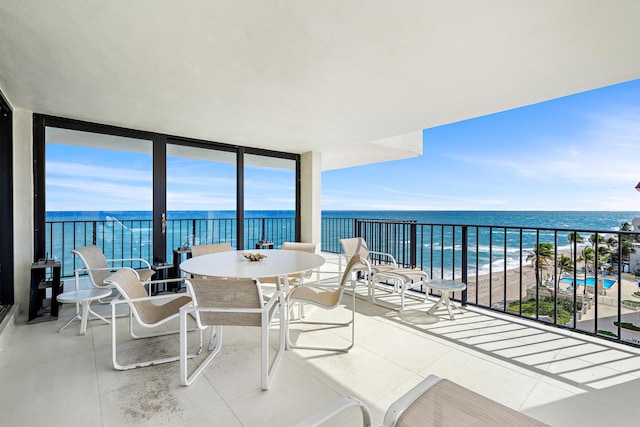 balcony featuring a beach view and a water view