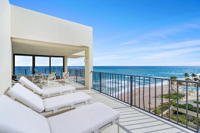 balcony featuring a water view and a beach view