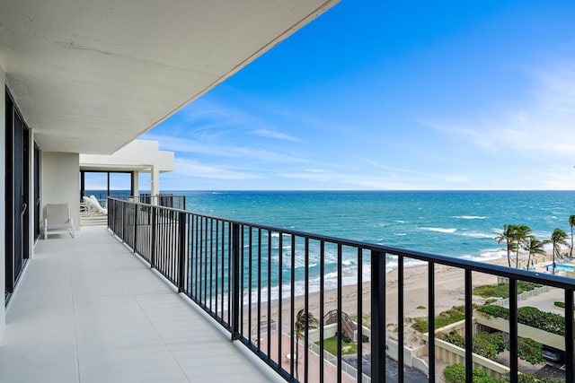 balcony featuring a water view and a view of the beach