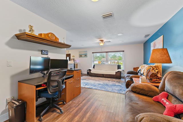 home office with ceiling fan, wood-type flooring, and a textured ceiling