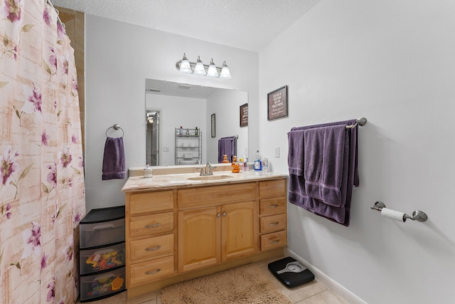 bathroom with vanity, tile patterned flooring, and a textured ceiling