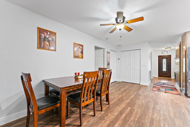 dining space featuring a textured ceiling, ceiling fan, and hardwood / wood-style flooring