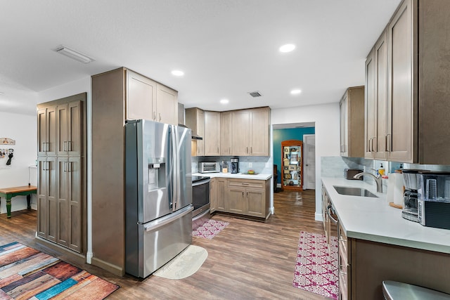 kitchen featuring appliances with stainless steel finishes, decorative backsplash, dark hardwood / wood-style floors, and sink