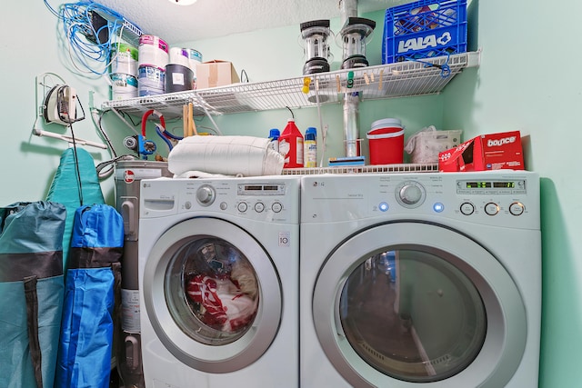 laundry room featuring a textured ceiling and washer and clothes dryer