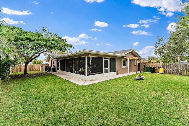 rear view of property with a sunroom and a yard