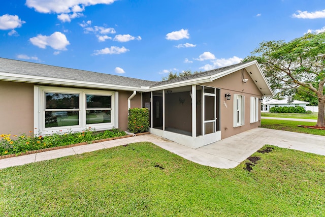 view of front facade with a front yard and a sunroom