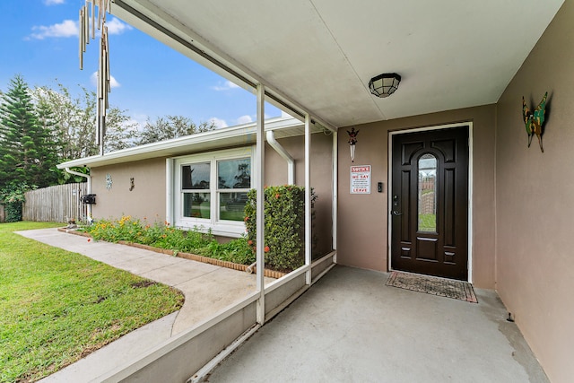 property entrance with a lawn