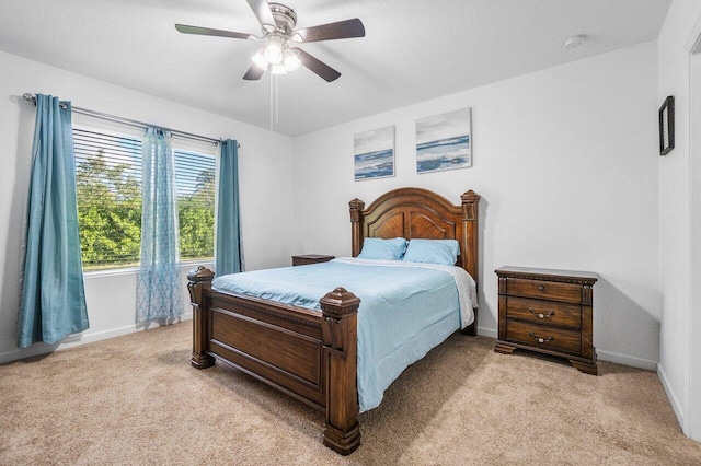 bedroom with ceiling fan and light carpet