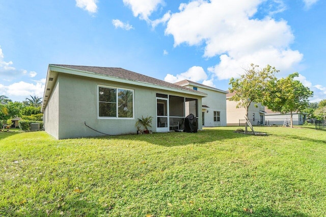 rear view of property with a lawn and a sunroom