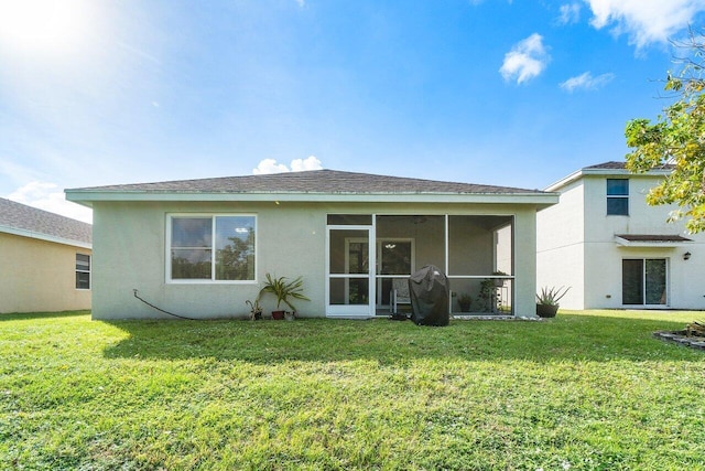 rear view of house with a sunroom and a yard