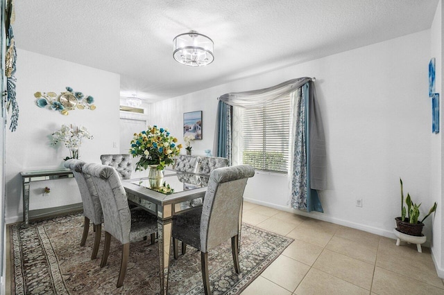 dining space with light tile patterned floors and a textured ceiling