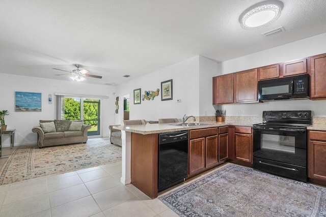 kitchen featuring sink, kitchen peninsula, a textured ceiling, light tile patterned floors, and black appliances