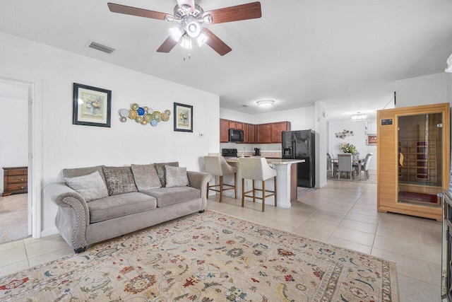 living room featuring ceiling fan and light tile patterned flooring