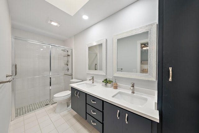 bathroom with toilet, a stall shower, and a sink