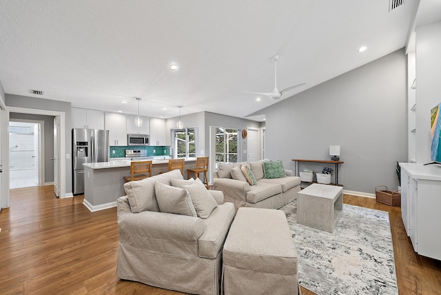 living area with visible vents, recessed lighting, baseboards, and wood finished floors