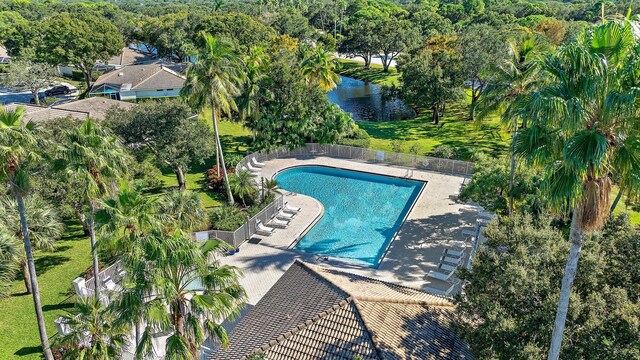 pool with a lawn, a patio, and a water view