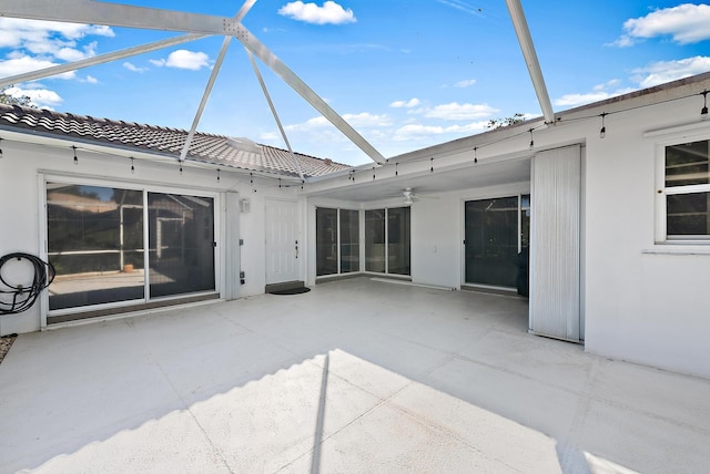 view of patio / terrace featuring a ceiling fan and a lanai