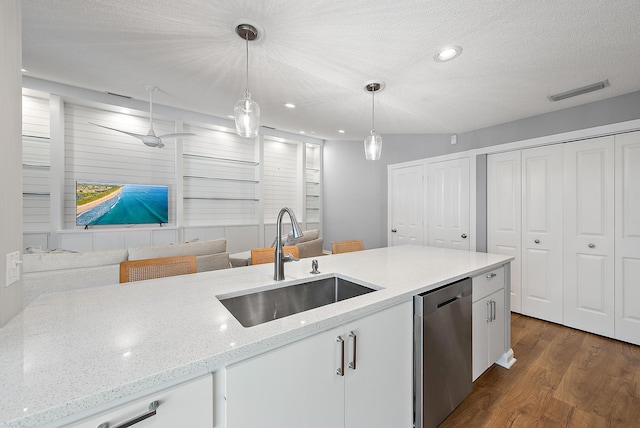 kitchen with pendant lighting, a sink, a textured ceiling, dishwasher, and dark wood-style flooring