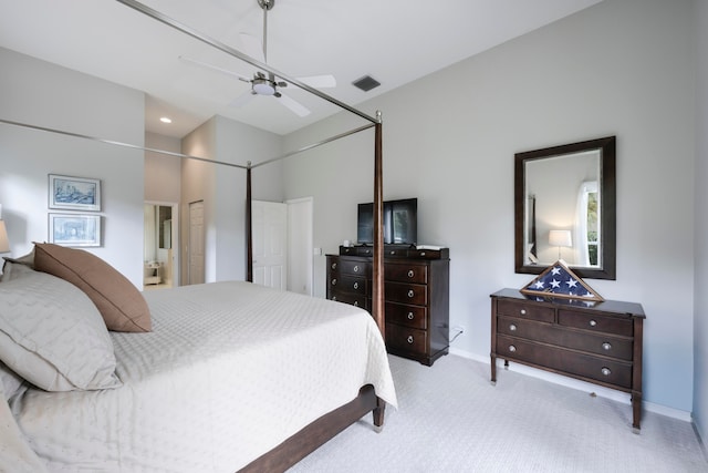 bedroom with connected bathroom, light colored carpet, and ceiling fan