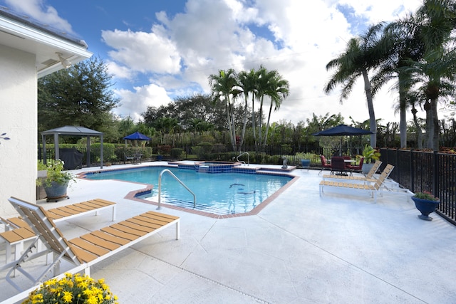 view of swimming pool featuring an in ground hot tub, a gazebo, and a patio area