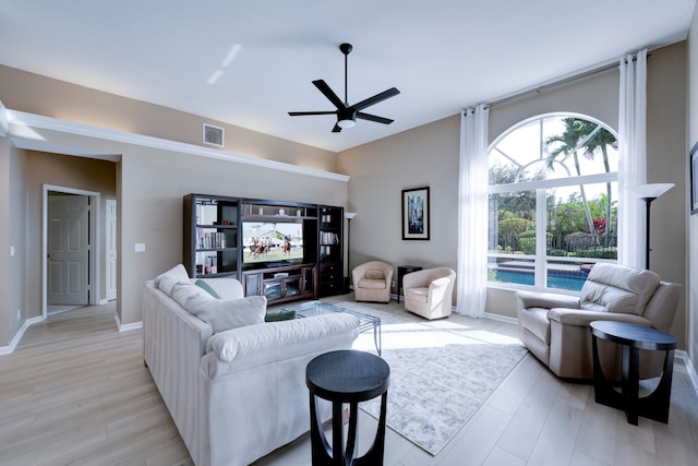 living room with light hardwood / wood-style flooring and ceiling fan