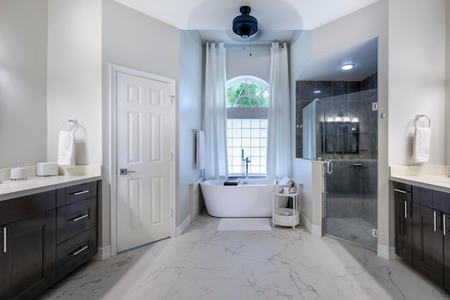 bathroom with vanity and shower with separate bathtub