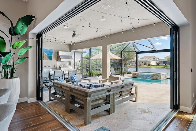 view of patio featuring an outdoor kitchen, a lanai, and a pool with hot tub