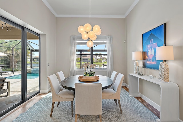 dining space with hardwood / wood-style floors, an inviting chandelier, and ornamental molding