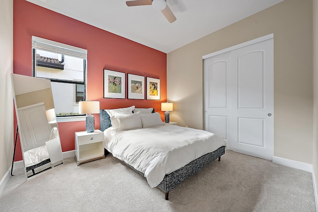 carpeted bedroom featuring ceiling fan and a closet