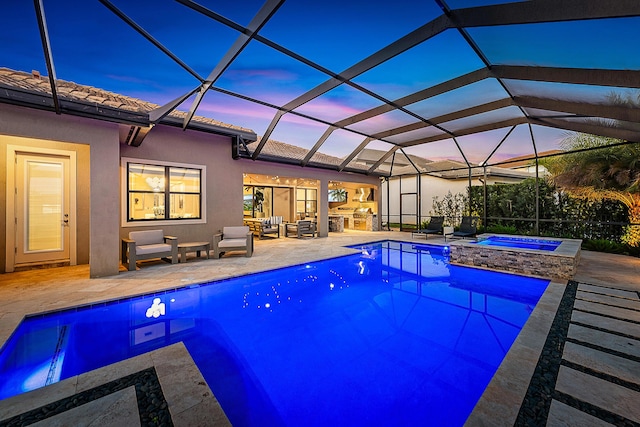 pool at dusk featuring a lanai, an in ground hot tub, and a patio