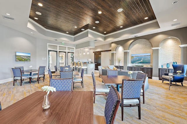 dining space featuring a tray ceiling, wood ceiling, and ornamental molding