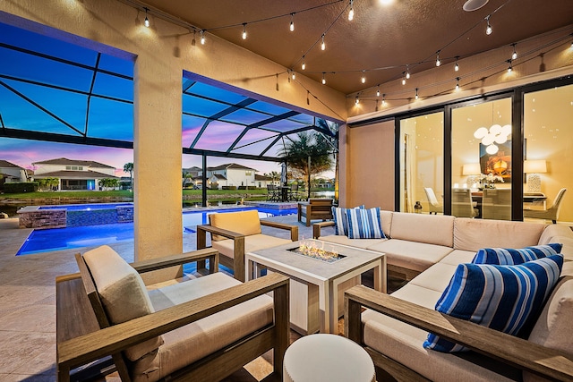 patio terrace at dusk with a lanai and an outdoor living space with a fire pit