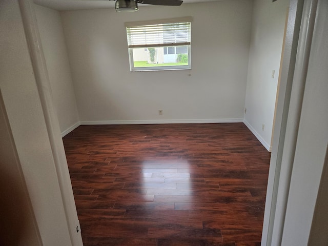 spare room with dark wood-type flooring and ceiling fan