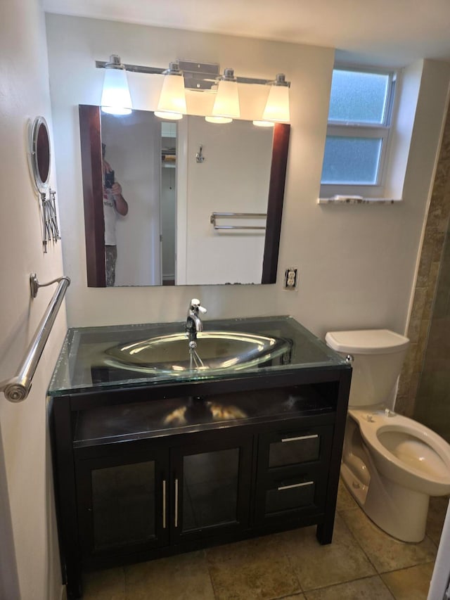 bathroom with toilet, vanity, and tile patterned flooring