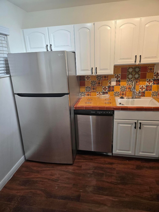 kitchen with white cabinets, sink, tile counters, and stainless steel appliances