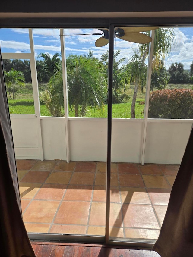 unfurnished sunroom featuring ceiling fan