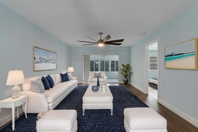 living room with dark hardwood / wood-style flooring, ceiling fan, and a healthy amount of sunlight