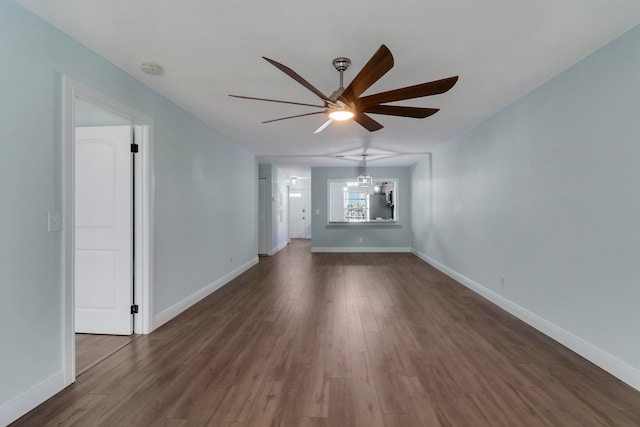 spare room with dark hardwood / wood-style floors and ceiling fan with notable chandelier