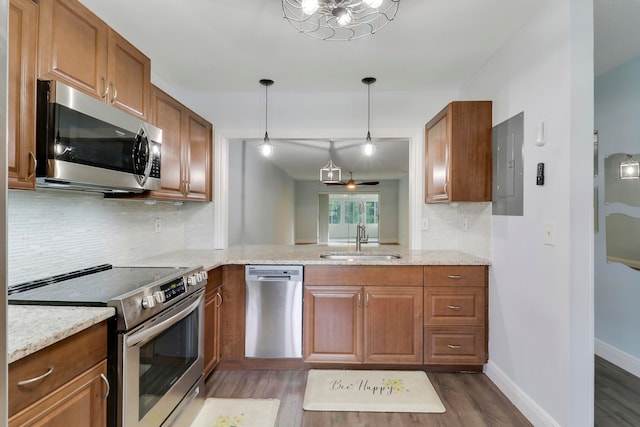 kitchen featuring electric panel, sink, light hardwood / wood-style flooring, and appliances with stainless steel finishes